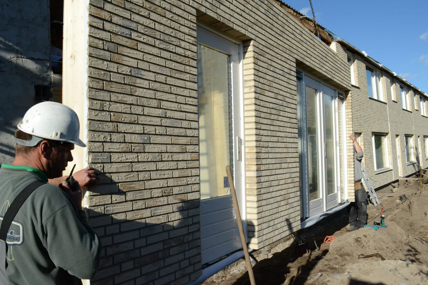 Installers position an Elastolith-clad prefabricated façade panel in Drunen